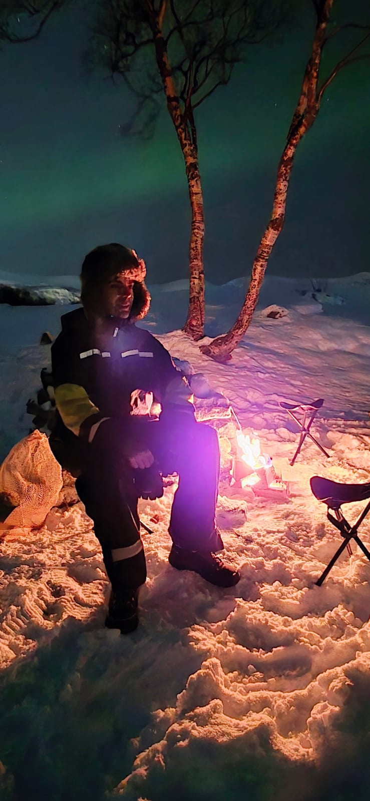 A guest by the campfire under the Northern Lights