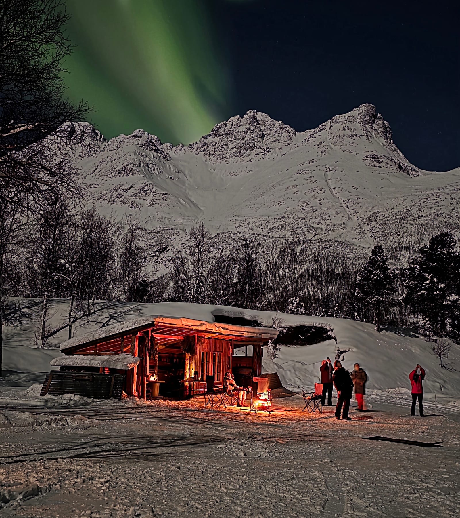 The basecamp cabin in the snow, with mountains behind