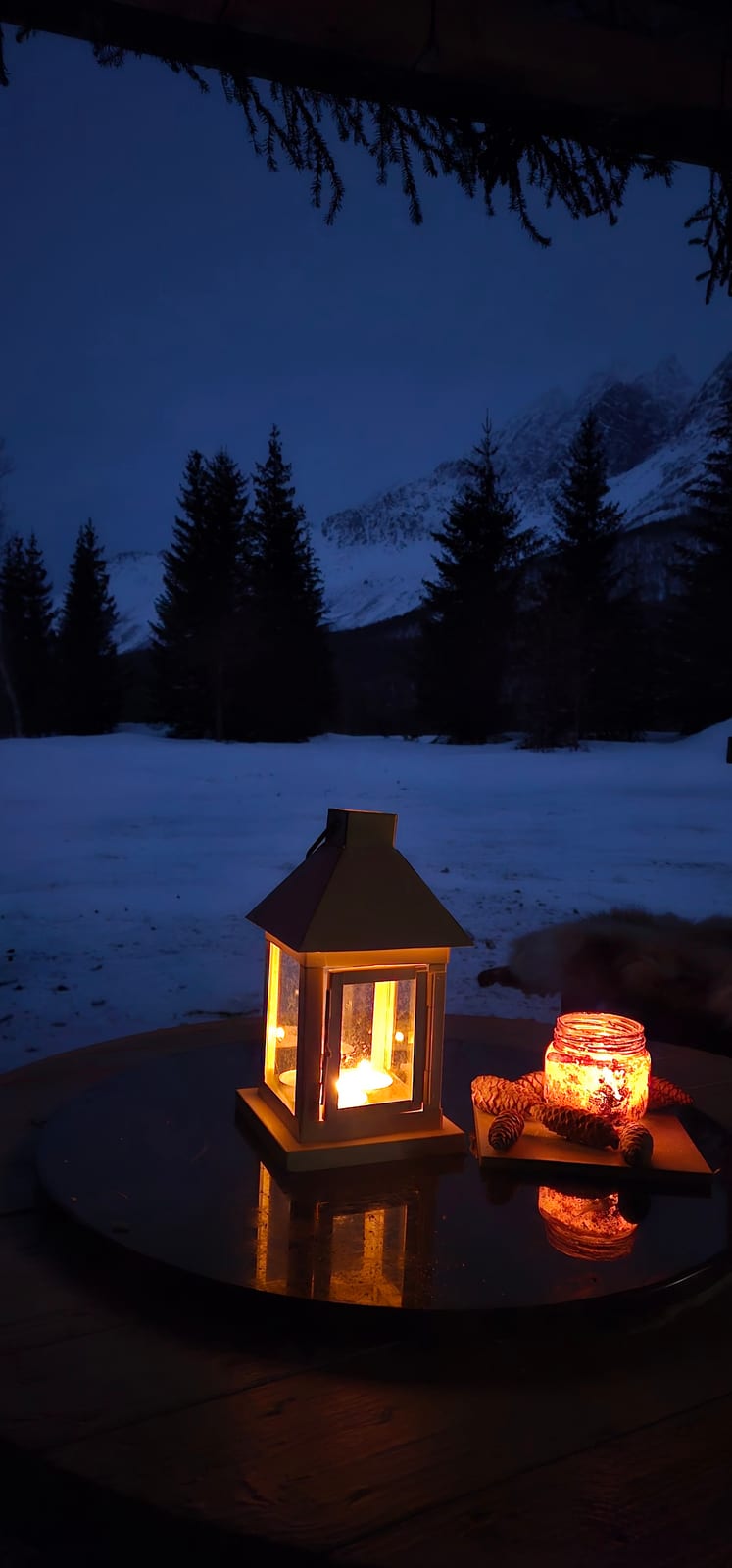 A lantern on the table outside the cabin in the evening